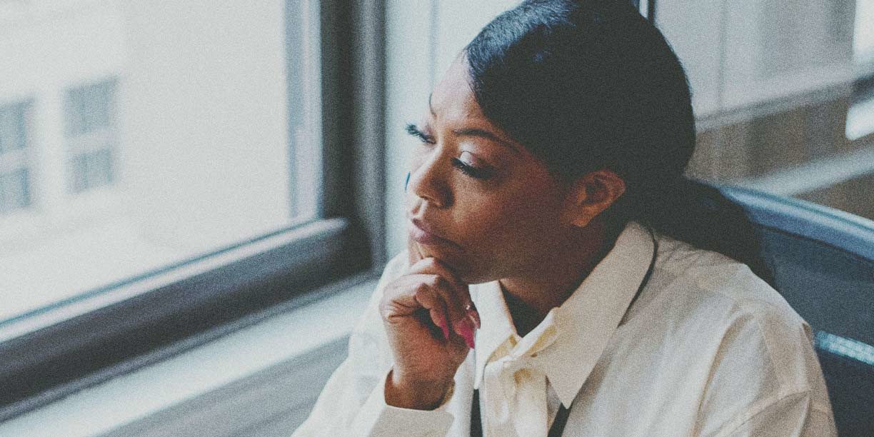 woman in white sitting and thinking