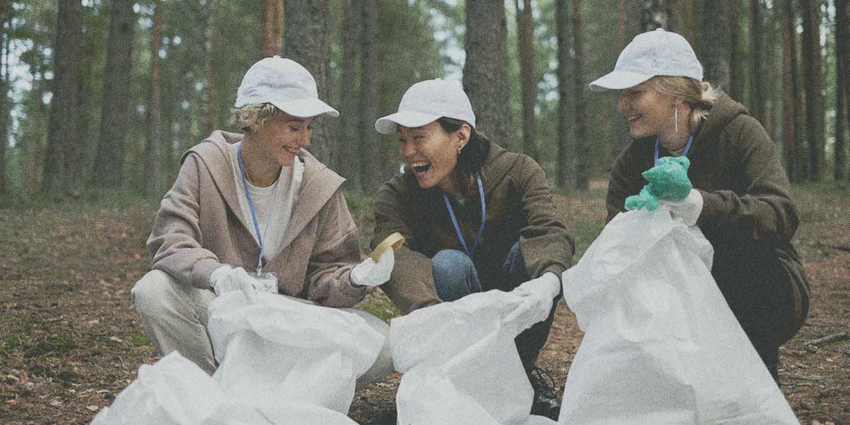 volunteers in brown with white hats picking up trash