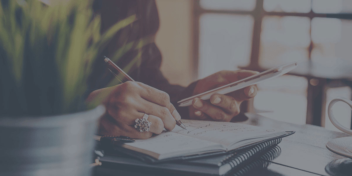 woman taking notes on notebook