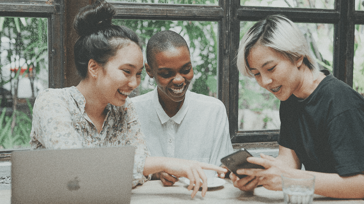 three people looking at phone